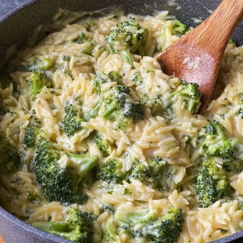 A bowl of pasta with broccoli and cheddar cheese.