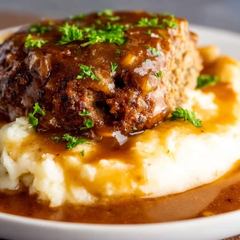 A plate of food with a piece of meat on top.